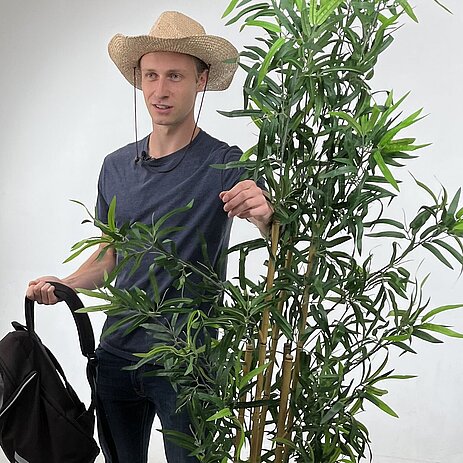 Christian, 21 jahre, blond, mit Hut und Rucksack im Fotostudio 