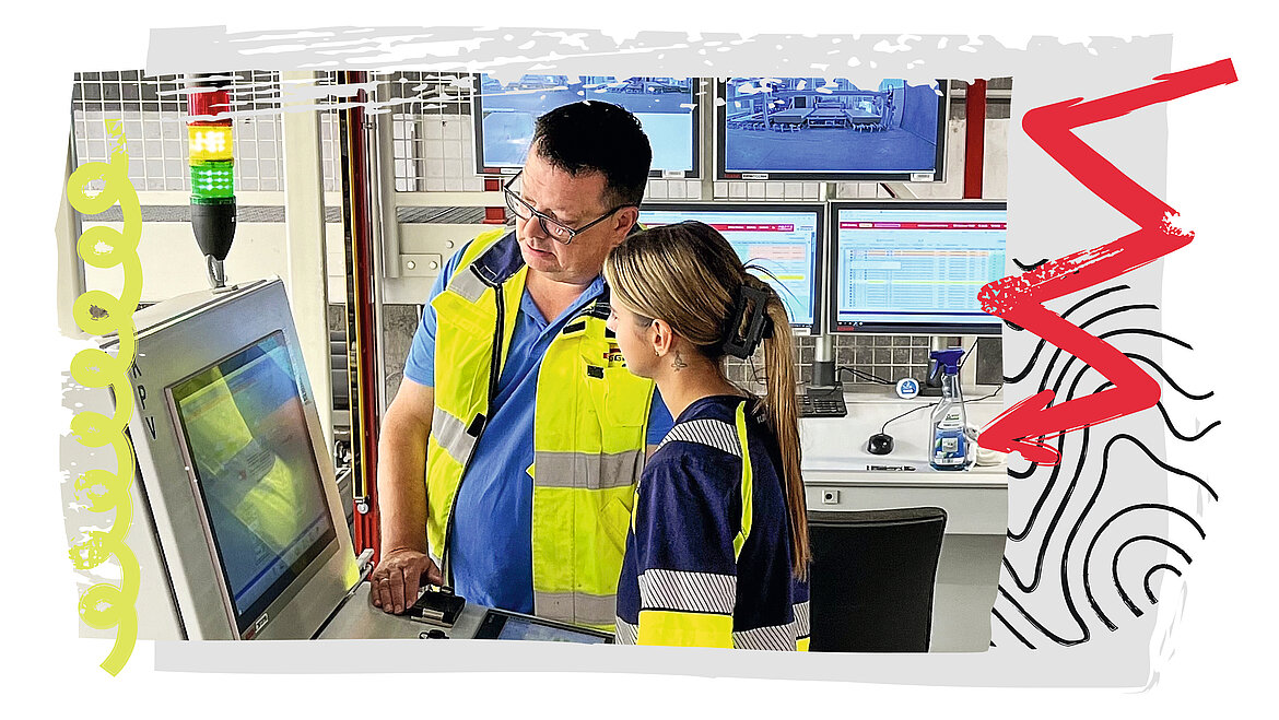 Auszubildende und Ausbilder in EGGER Arbeitskleidung an einer Anlage